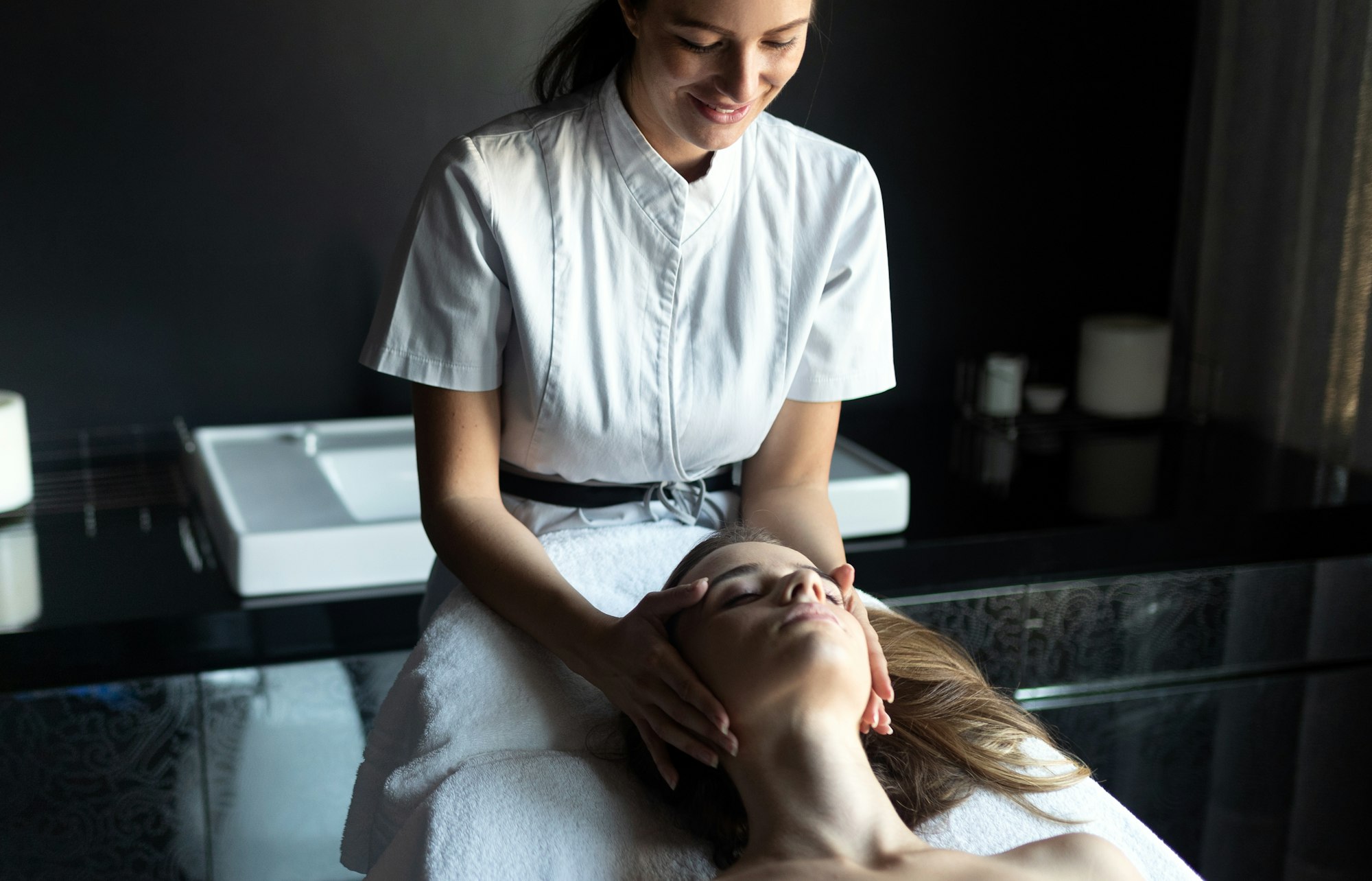 Beautiful young woman relaxing with massage treatment at beauty spa