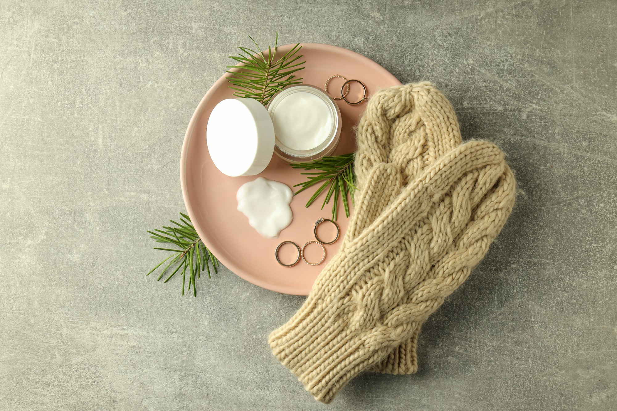 Concept of winter cosmetic products on gray textured table