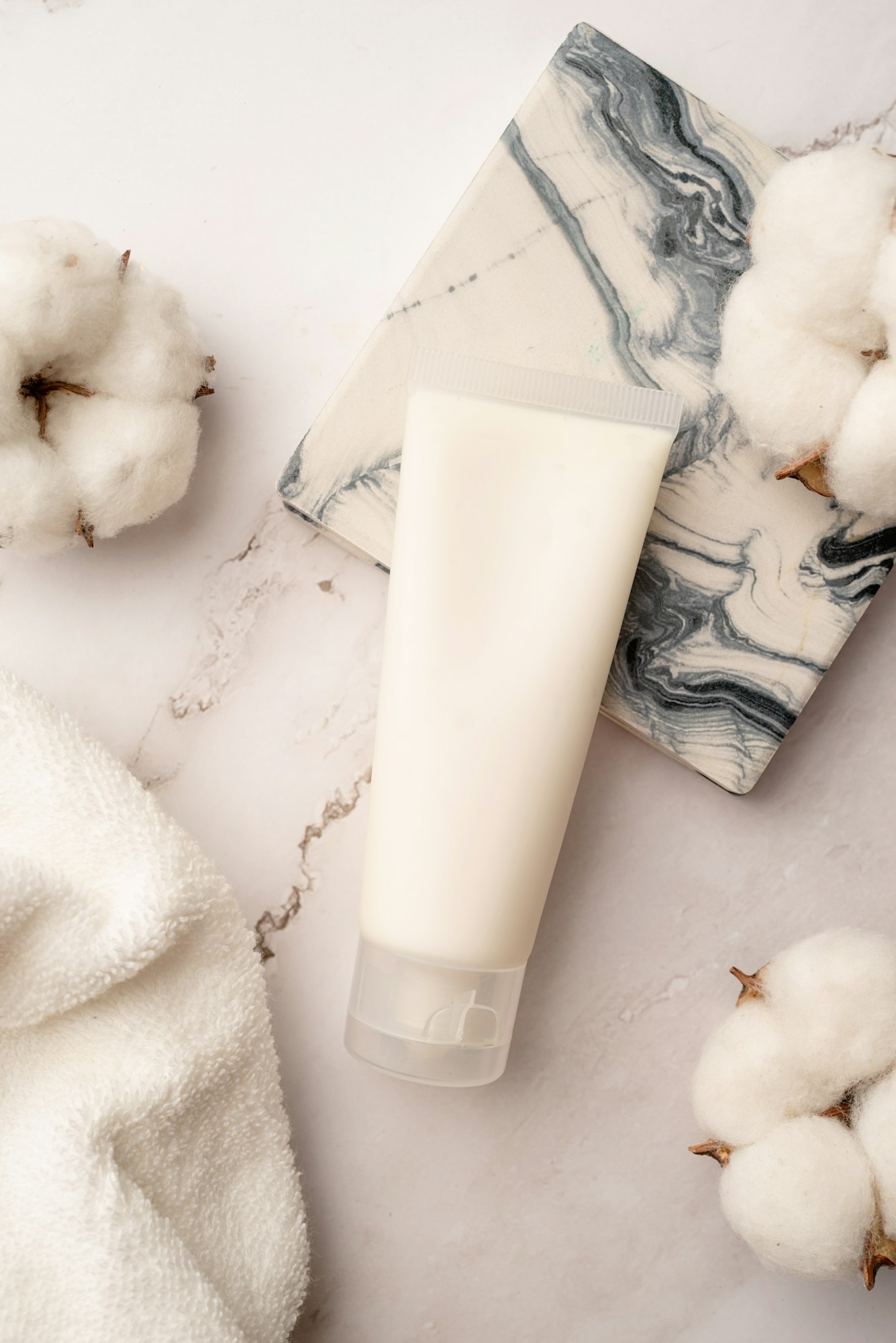 Top view Mockup facial skincare product white tube with blank label on marble background